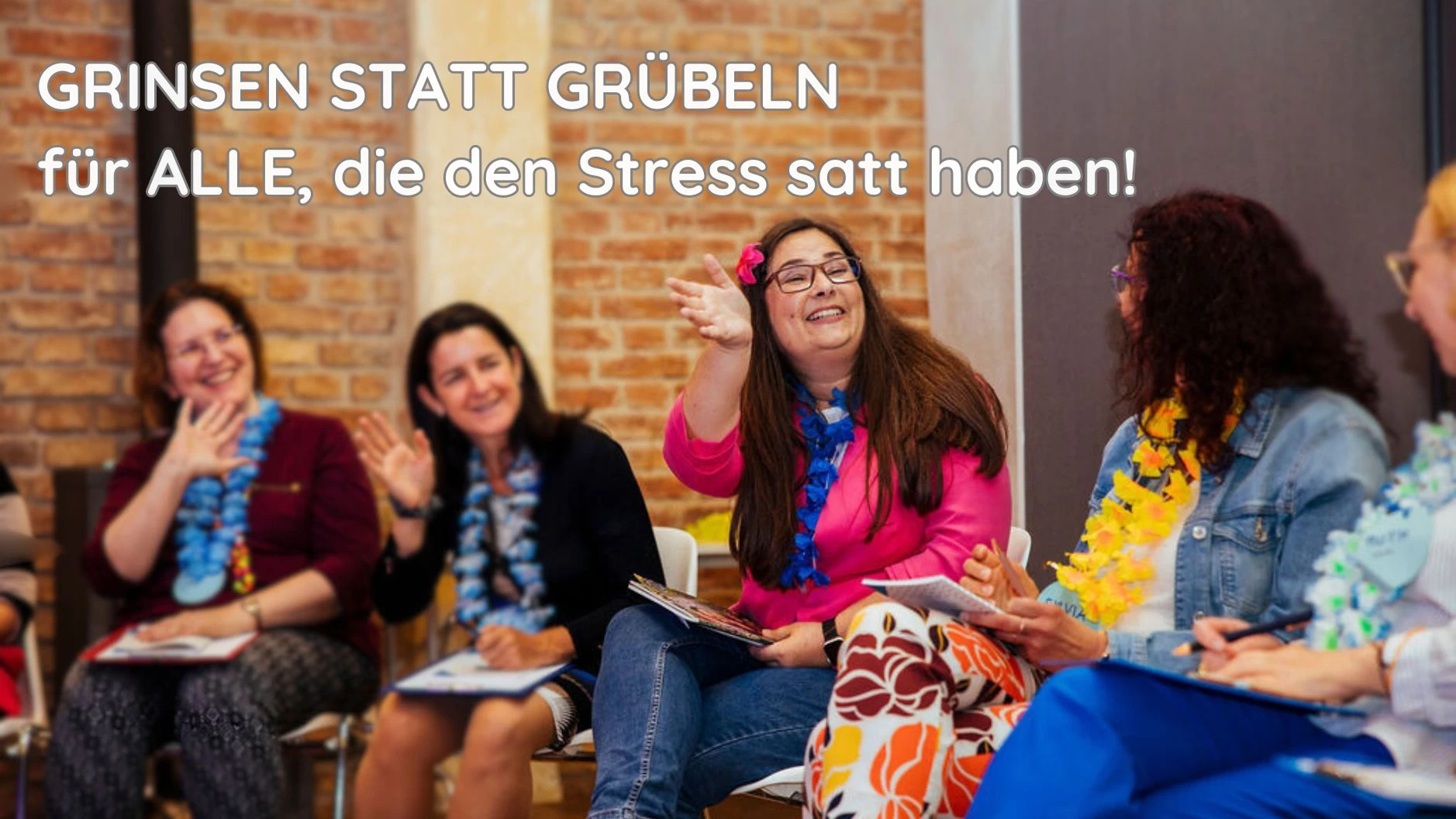 Michaela Sulzbacher sitzt im Halbkreis mit ihren Teilnehmerinnen. Alle winken sich zu und lächeln den Stress weg.